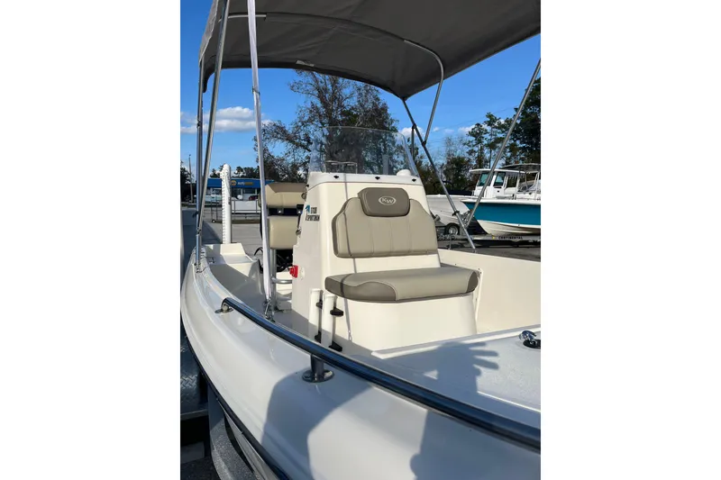 Slide: The Image of 2022 Key West 1720 Sportsman boat with canopy and seating, docked outdoors. - 12