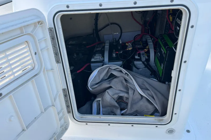 Slide: The Image of Open storage compartment of 2022 Key West 1720 Sportsman boat, showing batteries and wiring. - 19