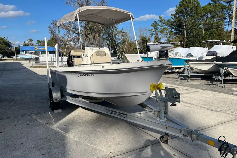 Slide: The Image of 2022 Key West 1720 Sportsman boat on trailer, parked outdoors under clear sky. - 2