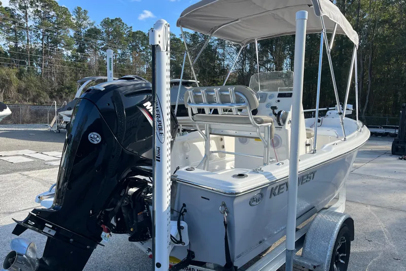 Slide: The Image of 2022 Key West 1720 Sportsman boat with outboard motor and canopy, parked on a trailer. - 7