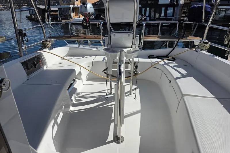 Slide: The Image of 2007 Hunter 44 Deck Salon yacht cockpit with seating and steering wheel, docked by the water. - 22