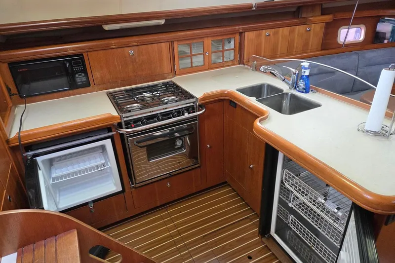 Slide: The Image of 2007 Hunter 44 Deck Salon galley with stove, microwave, fridge, freezer, and double sink. - 3