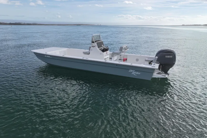The Image of 2024 Bay Rider 2460 Skiff on calm water, featuring Yamaha outboard motor. - 0