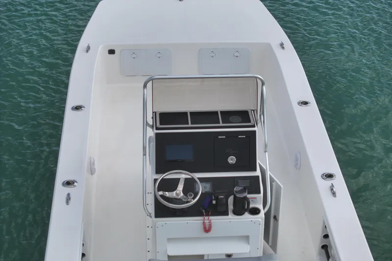 Slide: The Image of 2024 Bay Rider 2460 Skiff boat interior with steering console on water. - 12