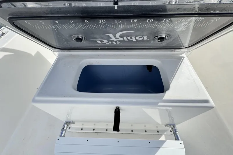 Slide: The Image of Open storage compartment on 2024 Bay Rider 2460 Skiff boat, featuring a measuring scale. - 15