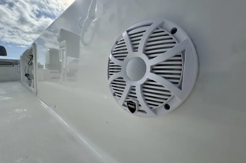 Slide: The Image of 2024 Bay Rider 2460 Skiff with marine speaker, clear sky reflection. - 16