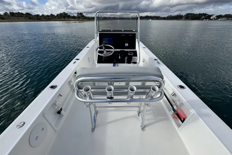 Slide: The Image of 2024 Bay Rider 2460 Skiff on calm water, featuring a sleek console and seating. - 22