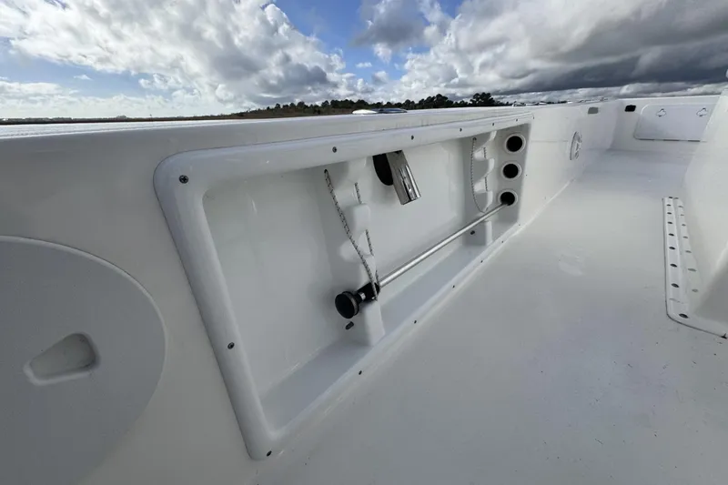 Slide: The Image of 2024 Bay Rider 2460 Skiff interior detail with storage compartments under a cloudy sky. - 24