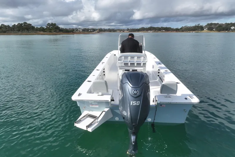 Slide: The Image of 2024 Bay Rider 2460 Skiff on calm water, featuring a powerful outboard motor. - 6