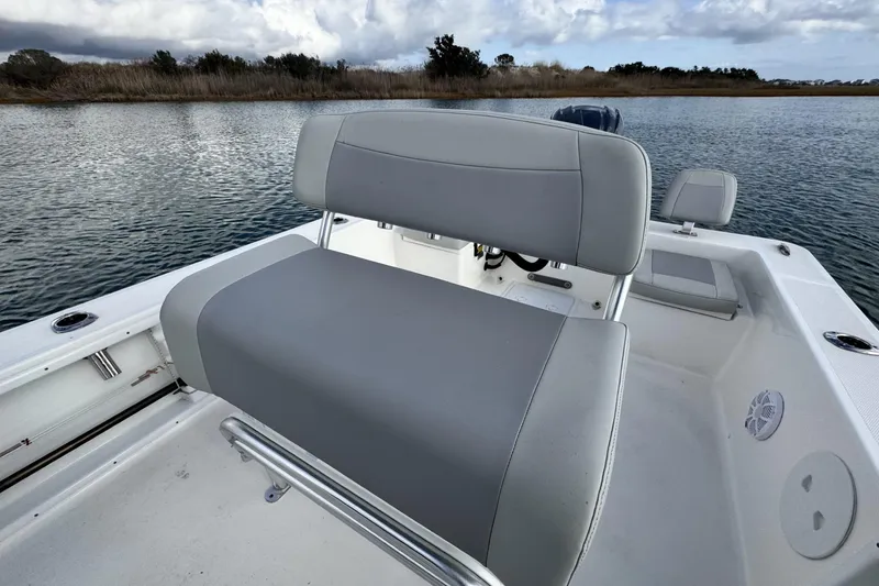 Slide: The Image of 2024 Bay Rider 2460 Skiff boat interior with gray seating, on calm water. - 8