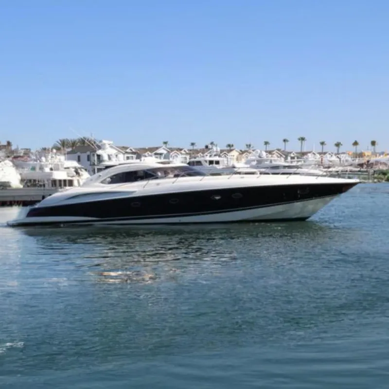 The Image of Sunseeker Predator 60 yacht, 2000 model, cruising in a marina with palm trees. - 0