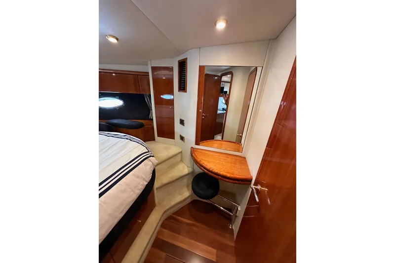Slide: The Image of Sunseeker Predator 60 yacht interior, 2000 model, featuring a cozy bedroom with elegant wood finishes. - 105