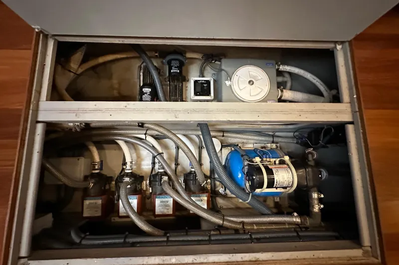 Slide: The Image of Engine compartment of a 2000 Sunseeker Predator 60 yacht, showcasing mechanical components and hoses. - 111