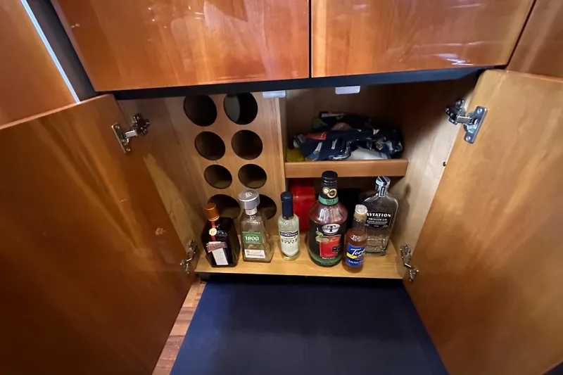 Slide: The Image of Liquor cabinet inside a 2000 Sunseeker Predator 60 yacht, featuring various bottles and storage. - 86