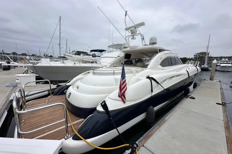 Slide: The Image of Luxury Sunseeker Predator 60 yacht docked at marina, 2000 model, with American flag. - 9