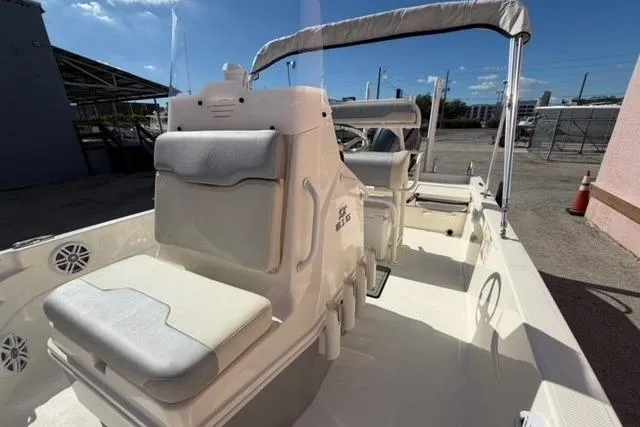 Slide: The Image of 2016 Skeeter SX210 boat interior with seating and console, parked outdoors under clear sky. - 11