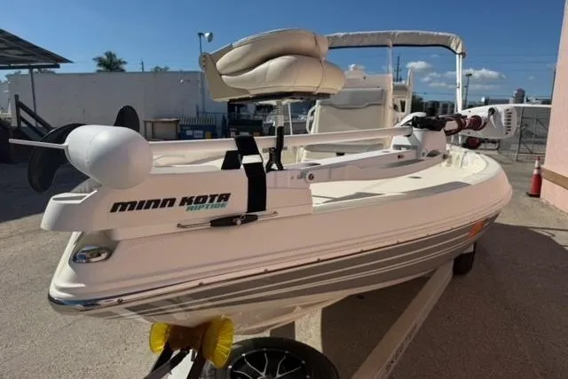 Slide: The Image of 2016 Skeeter SX210 boat with Minn Kota motor, parked on a trailer in sunny outdoor setting. - 16