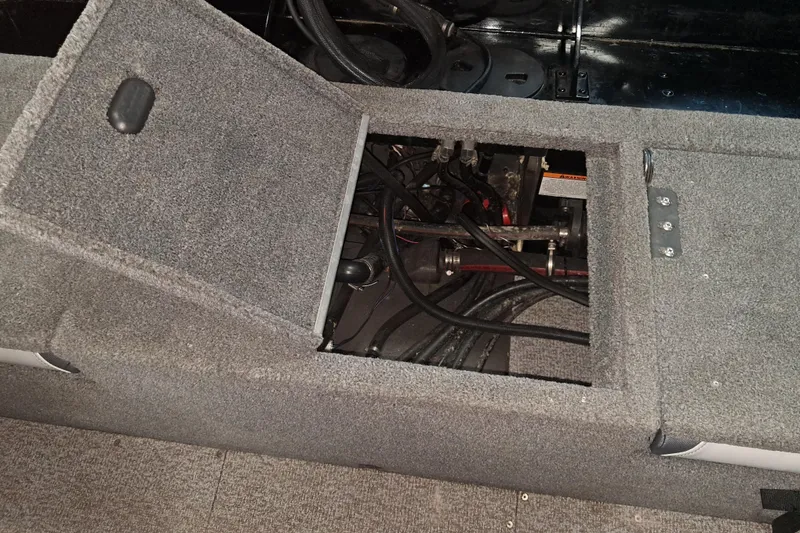 Slide: The Image of 2015 Alumacraft Trophy 175 boat interior showing open storage compartment with wiring. - 10