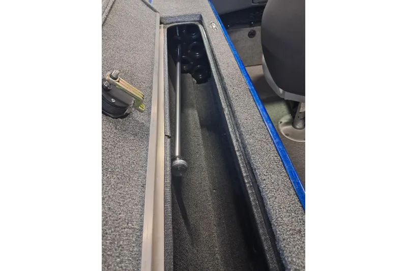 Slide: The Image of 2015 Alumacraft Trophy 175 boat interior storage compartment with rod holder. - 13