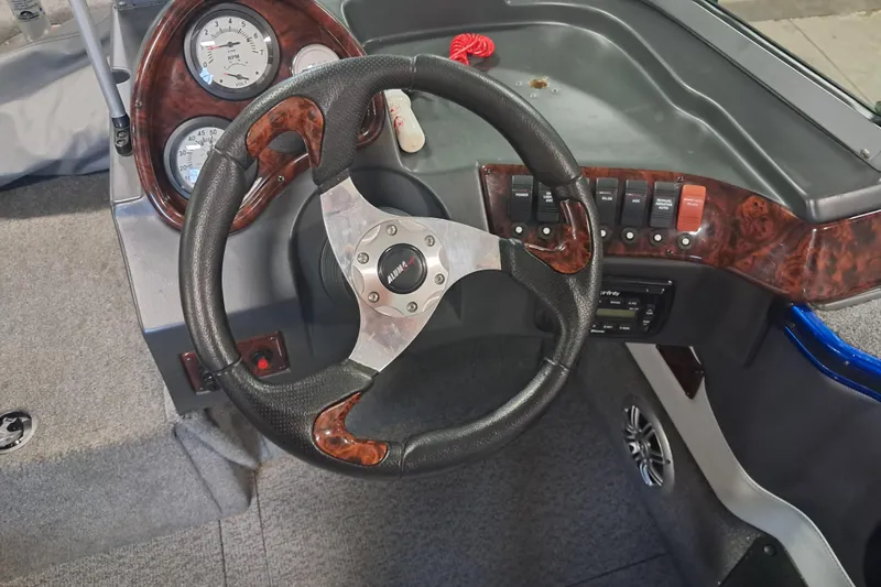 Slide: The Image of 2015 Alumacraft Trophy 175 boat dashboard with steering wheel and control panel. - 16