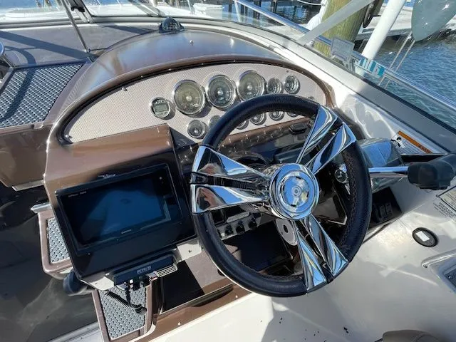Slide: The Image of Cockpit of a 2014 Regal 3550 Cuddy boat with shiny steering wheel. - 27