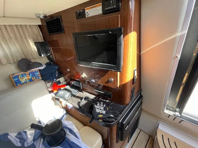 Slide: The Image of Interior of a 2014 Regal 3550 Cuddy boat with TV and seating area. - 33