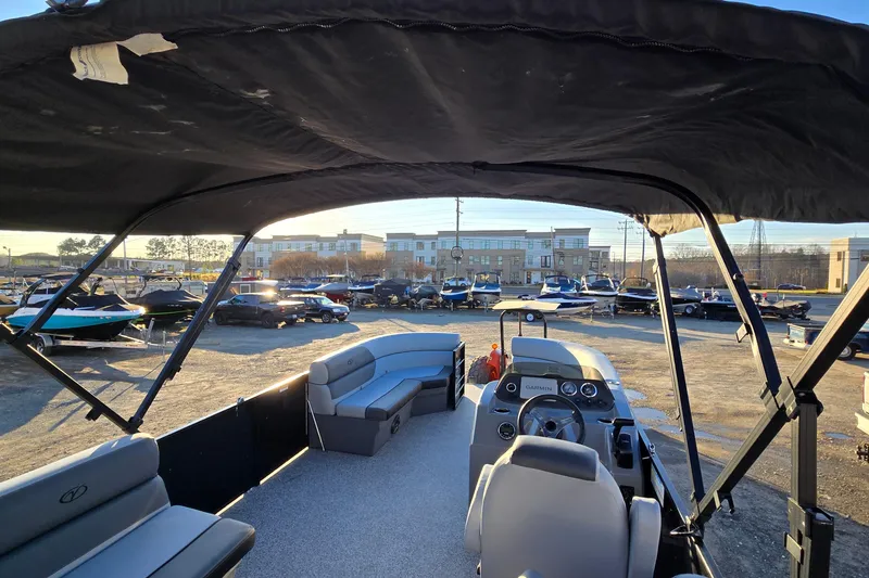 Slide: The Image of 2023 Veranda Vista View 20RC pontoon boat interior with canopy, parked in a marina. - 25