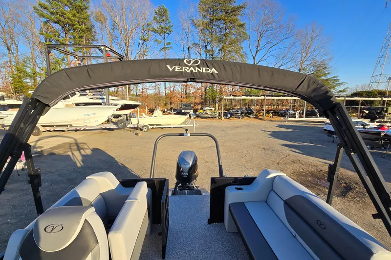 Slide: The Image of 2023 Veranda Vista View 20RC pontoon boat with seating, motor, and canopy in a sunny outdoor setting. - 26
