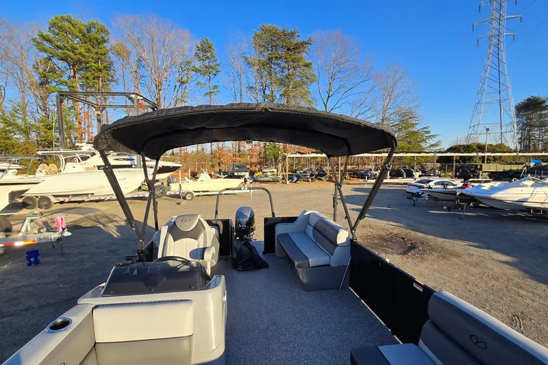 Slide: The Image of 2023 Veranda Vista View 20RC pontoon boat with canopy in a marina setting. - 27