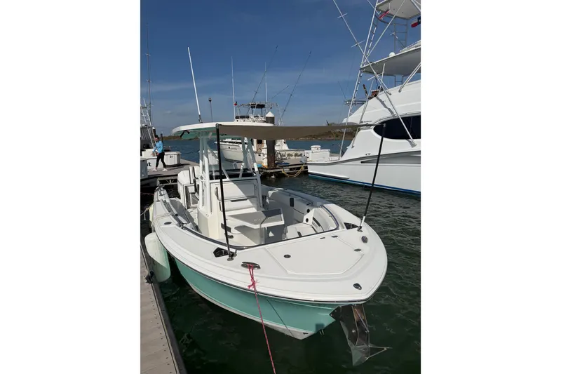 Slide: The Image of 2021 Blackfin 252 CC boat docked at marina, clear sky background. - 2
