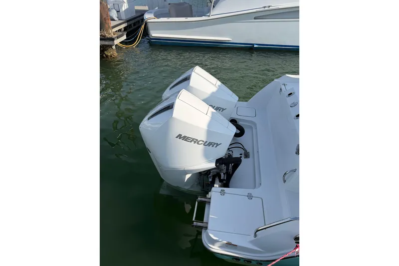 Slide: The Image of 2021 Blackfin 252 CC with dual Mercury outboard engines docked in marina. - 20