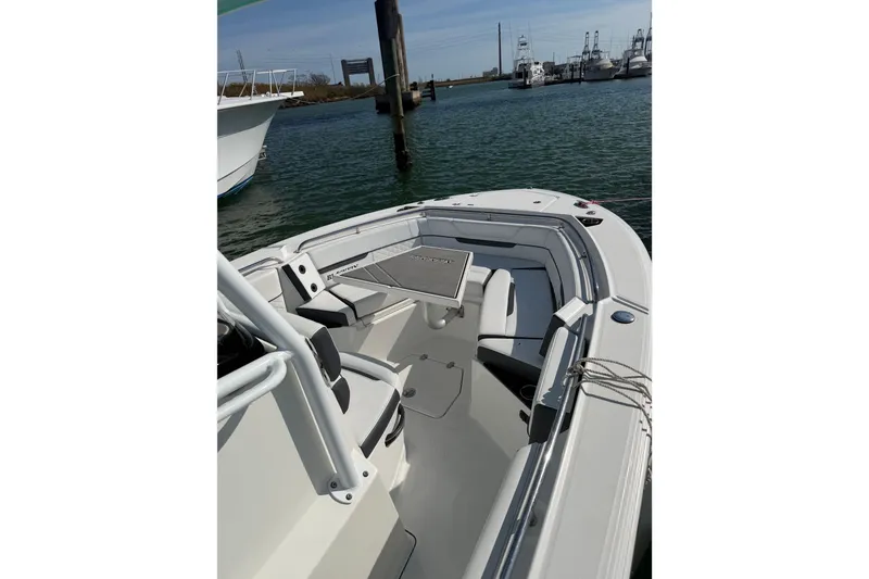 Slide: The Image of 2021 Blackfin 252 CC boat docked in a marina, showcasing spacious seating and sleek design. - 5