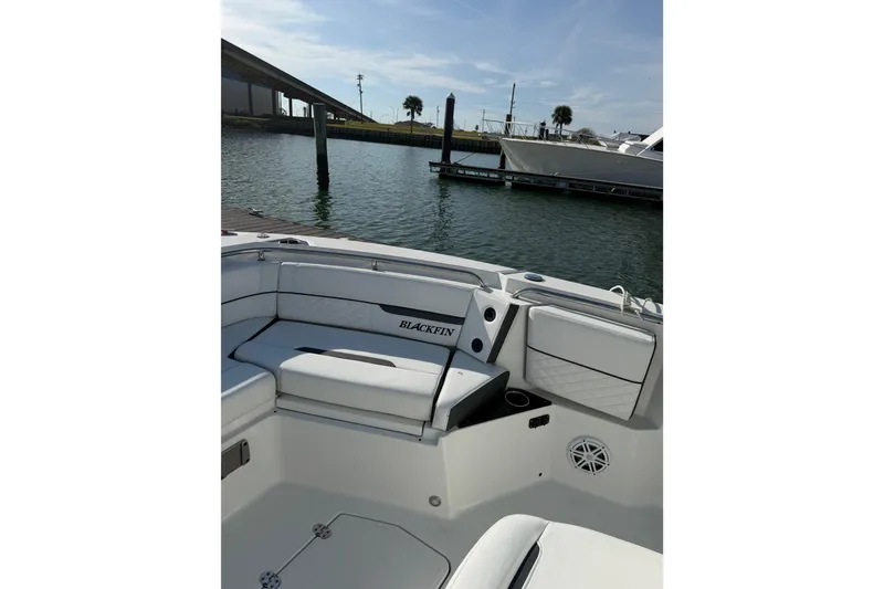Slide: The Image of 2021 Blackfin 252 CC boat interior with seating, docked by the water. - 7
