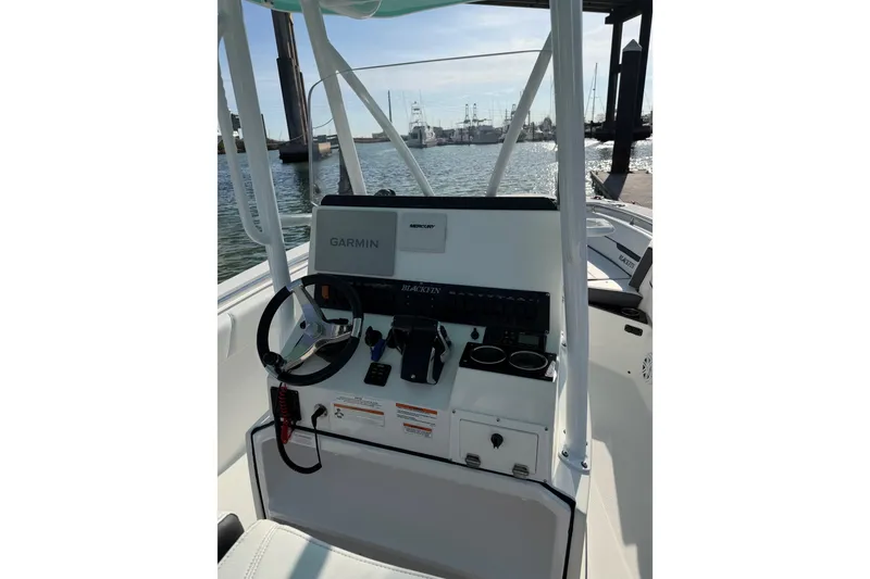 Slide: The Image of 2021 Blackfin 252 CC boat console with Garmin navigation, docked by the water. - 8