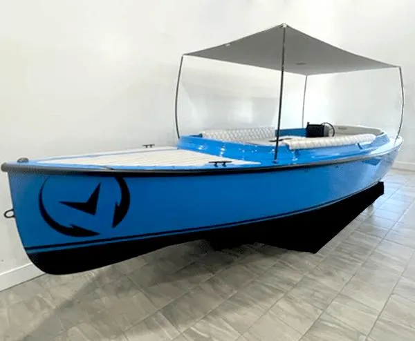 The Image of 2024 Vision Marine Technologies Fantail 217, blue electric boat with canopy, displayed indoors. - 0