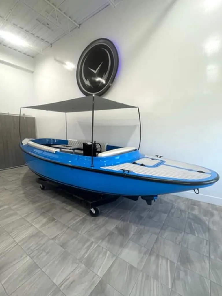 Slide: The Image of 2024 Vision Marine Technologies Fantail 217 electric boat in showroom, blue with canopy. - 4