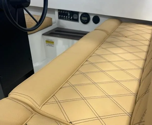 Slide: The Image of 2024 Vision Marine Technologies Fantail 217 interior with beige diamond-stitched seating and control panel. - 3