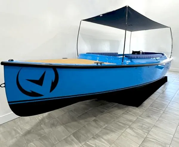 The Image of 2024 Vision Marine Technologies Fantail 217, blue electric boat with canopy, displayed indoors. - 0