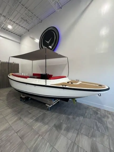 Slide: The Image of 2024 Vision Marine Technologies Fantail 217 boat with canopy, displayed indoors on tiled floor. - 1