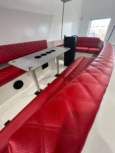 Slide: The Image of 2024 Vision Marine Technologies Fantail 217 interior with red seating and a central table. - 6
