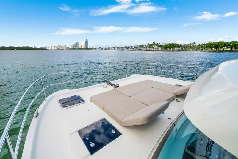 Slide: The Image of 2023 Fountaine Pajot MY4.S yacht deck with sunbed, overlooking scenic waterfront. - 10