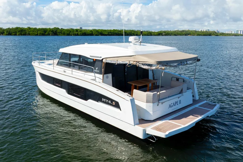 Slide: The Image of 2023 Fountaine Pajot MY4.S yacht on serene water, featuring spacious deck and modern design. - 12