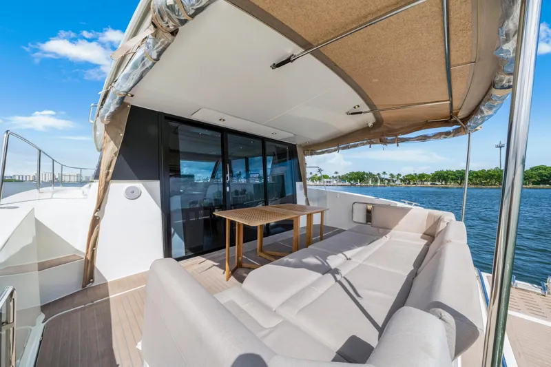 Slide: The Image of Luxurious 2023 Fountaine Pajot MY4.S yacht deck with seating and table, overlooking serene waters. - 19