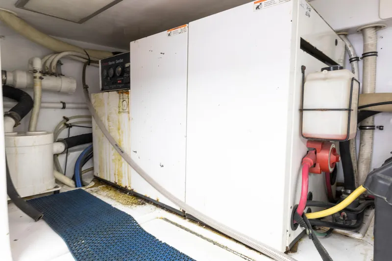 Slide: The Image of Engine room of a 2005 Weaver 61 yacht, featuring dual engines and blue piping. - 18