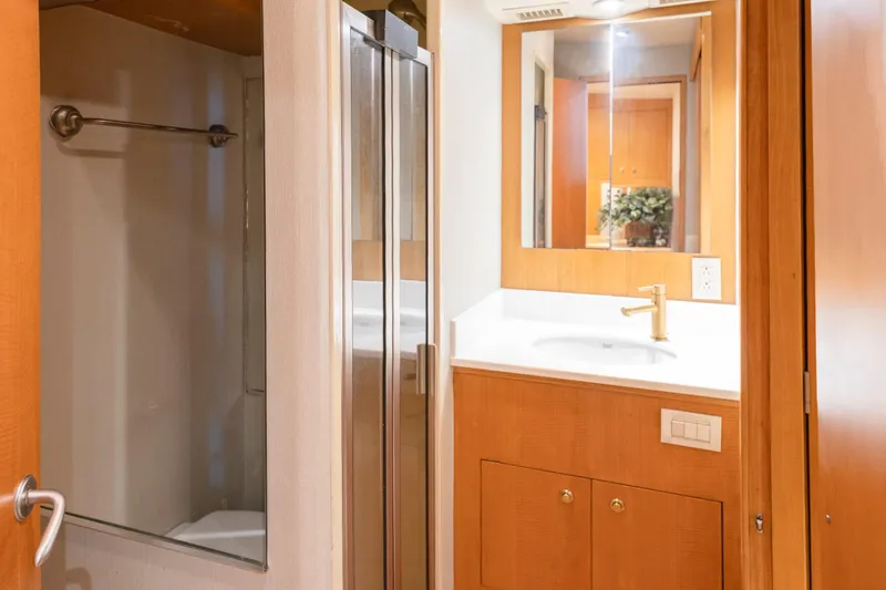 Slide: The Image of Engine room of a 2005 Weaver 61 yacht, featuring dual engines and blue piping. - 20