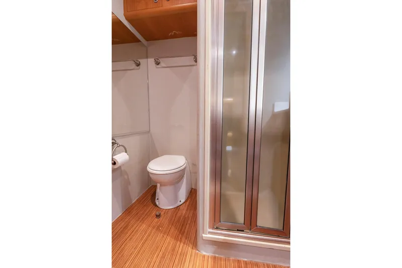 Slide: The Image of Wood-paneled bathroom interior of 2005 Weaver 61 yacht with mirror and storage cabinet. - 23