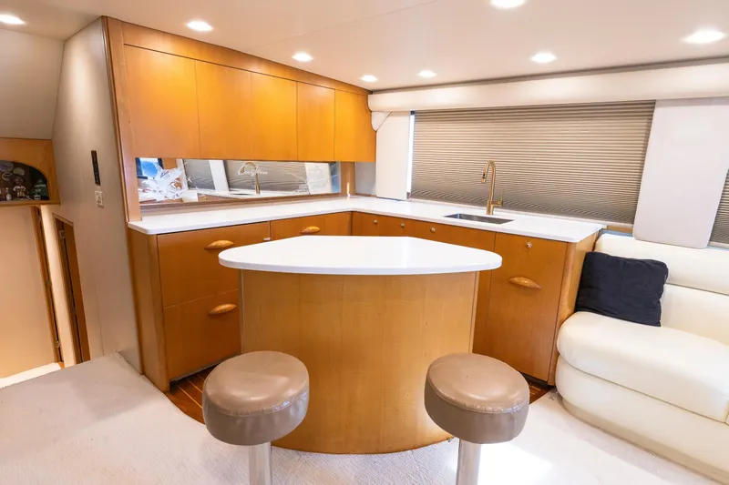 Slide: The Image of Luxurious Weaver 61 yacht interior with modern kitchen, bar stools, and elegant wood cabinetry, 2005 model. - 38