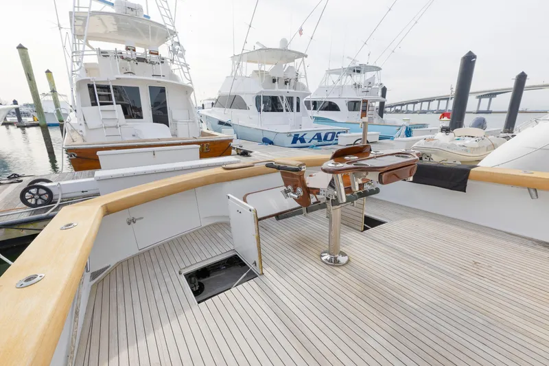 Slide: The Image of 2005 Weaver 61 yacht docked, featuring spacious deck and fishing chair setup. - 49