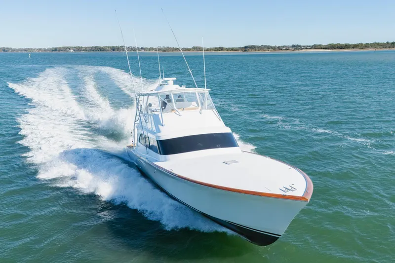 Slide: The Image of A 2005 Weaver 61 yacht cruising swiftly on open water under clear skies. - 58