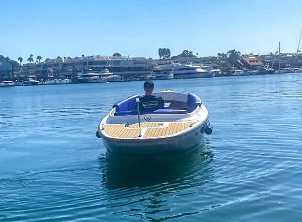 Slide: The Image of 2023 Vision Marine Technologies Fantail 217 boat on calm water, with a person onboard. - 1